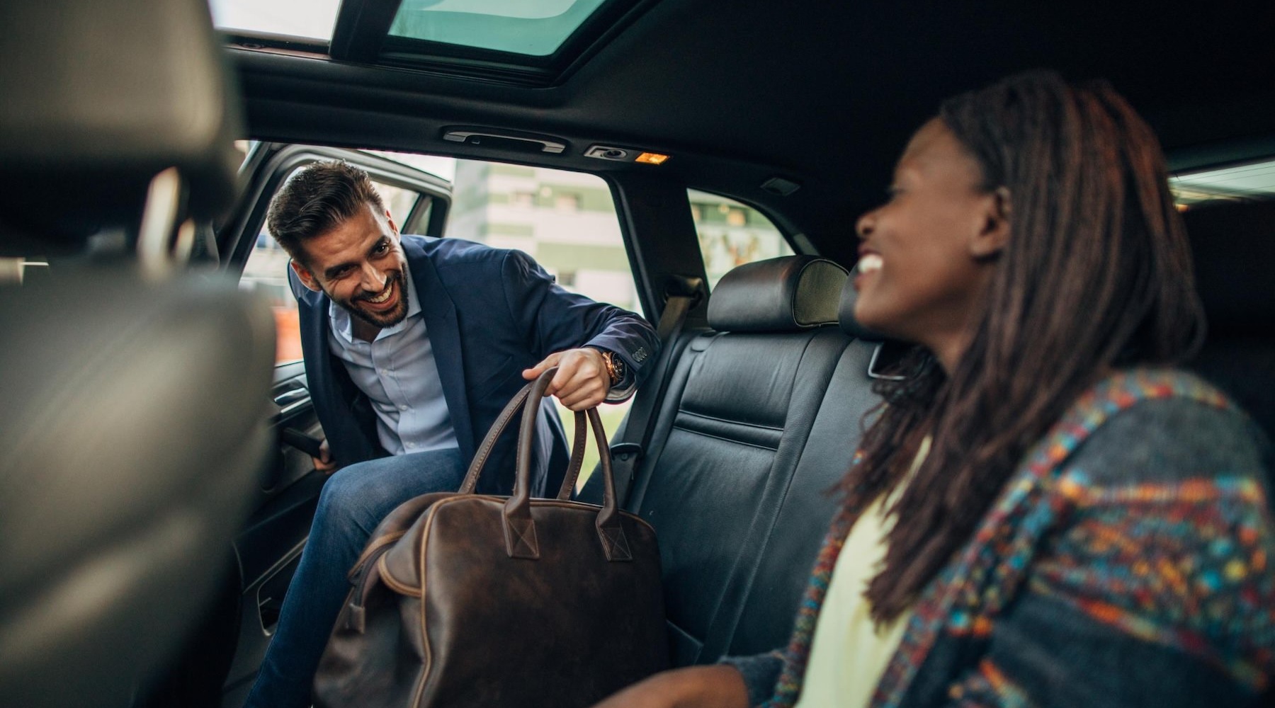 a man and a woman getting into a car