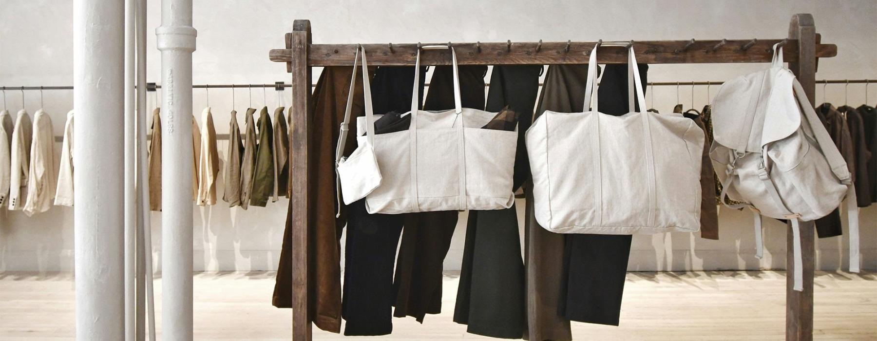 a row of clothes and bags on a rack